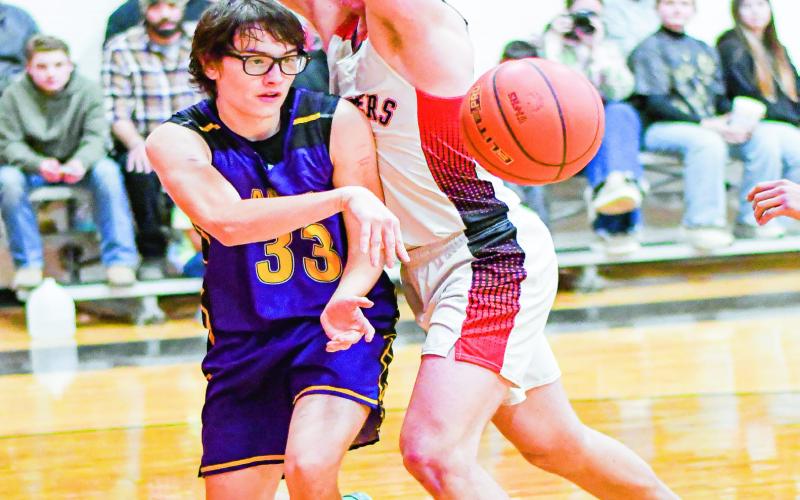 BULLDOGS VERSUS PANTHERS - Anton Bulldog Caleb Carlock makes a pass and Whitharral Panther Hudson Dobrovolny guards him closely during their district game at Whitharral High School this past Thursday. (Staff photo by Jentezen Smith)