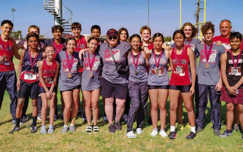 LOVE FOR THEIR COACH - LHS Head Track Coach Nelda Munoz leaves behind her mark on what is considered her track program. Countless LHS student-athletes competed under Coach Munoz and brought the program medals ranging from regular season meets all the way to the state level competition. Pictured is Coach Munoz with one of her former teams. (Photo courtesy of Nelda Munoz)