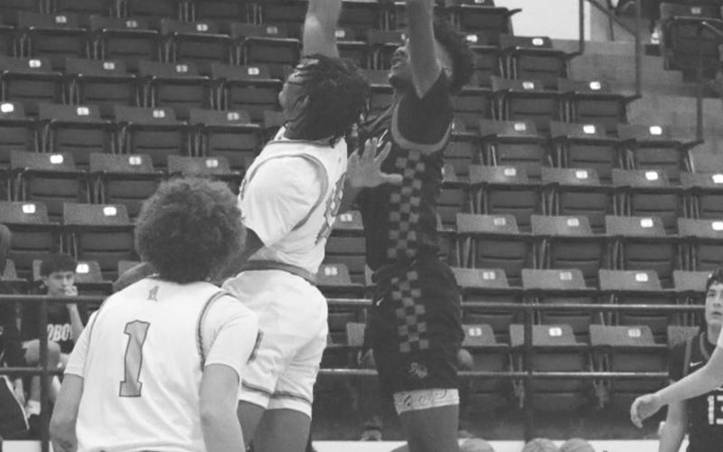 SKY HOOK - Levelland Lobo Eryk Jones shot the ball from under the basket with a sky hook over the defender during the team’s game at Frenship against Monterey. (Staff photo by Aalijah Soliz)