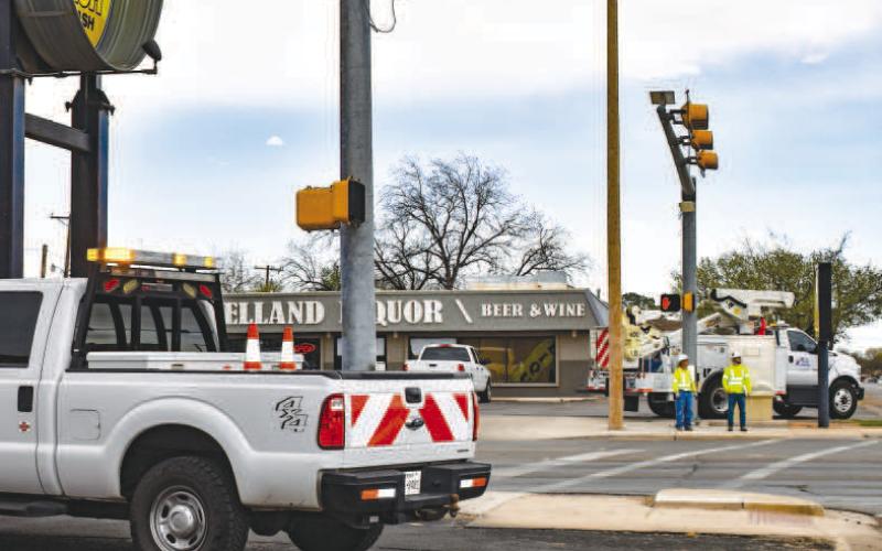 TRAFFIC LIGHT WORK - Texas Department of Transportation (TxDOT) crews were seen working on traffic lights at various intersection of College Avenue and Avenue H. Pictured is a TxDOT crew working on traffic lights at the intersection of College Avenue and 10th Street. (Staff photo by Emily Campos)