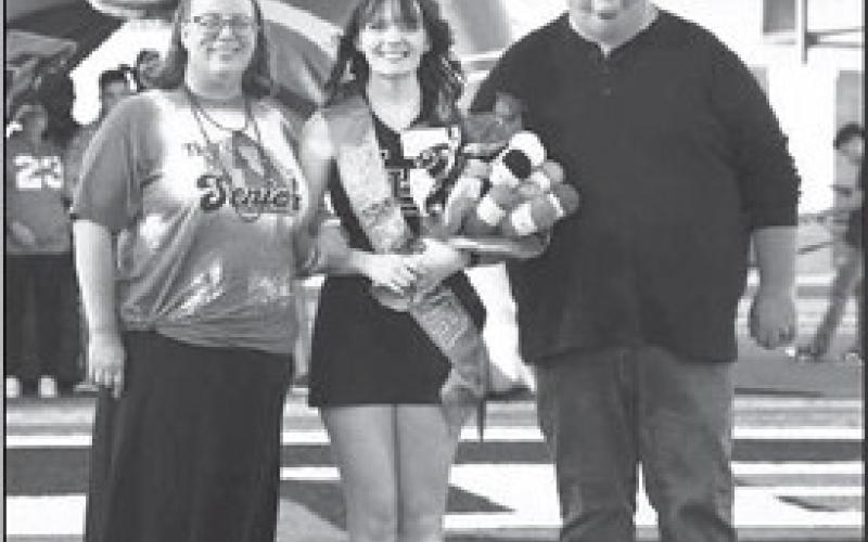 SENIORBANDANDCHEER- Levelland seniors were recognized last Friday during the Lobos home game against Borger. Cheerleaded and band member Samantha Young was escorted by her parents Jeff and Melissa Young. (Staff Photo by Dom Puente)