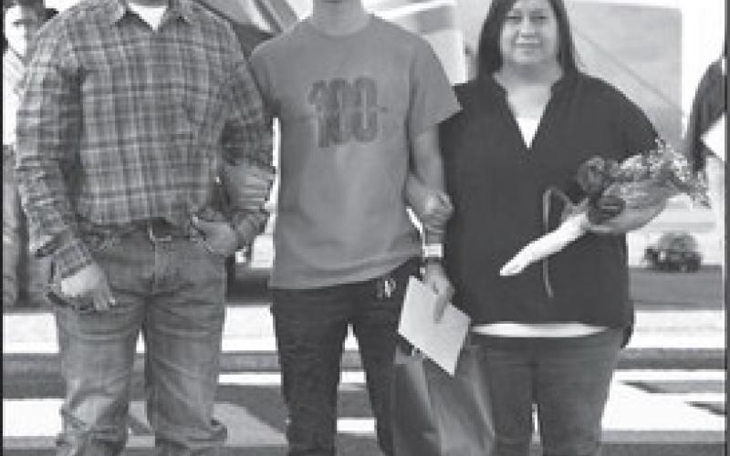 SENIOR LHS XC- Levelland seniors were recognized last Friday during the Lobos home game against Borger. Senior cross country runner Ethan Lozano was escorted by his parents Adrian Lozano and Veronica Ramirez. (Staff Photo by Dom Puente)