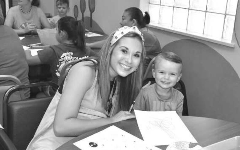 COLOR TIME - Chelsea Samsel and son Huxton Samsel enjoying the Hockley County Summer Reading Program at The Hockley County Library where they where able to color and draw pictures together. The Art and Apples program gave children the opportunity to have a snack with other participants of the program Wednesday.