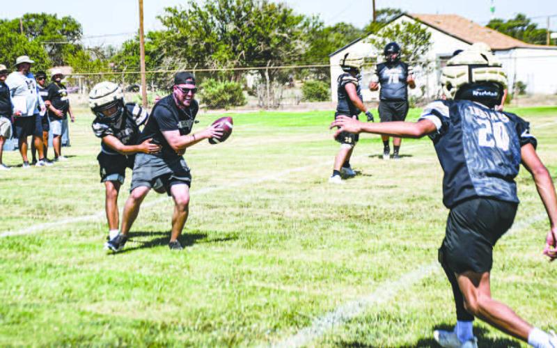 TACKLING COACH – Morton Football Head Coach Trevor Bulmer plays scout team quarterback and Rafael Acevedo wraps him up for the tackle while teammate Bryson Arteaga is in pursuit to help make the play at practice on August 5. (Staff photo by Jentezen Smith)