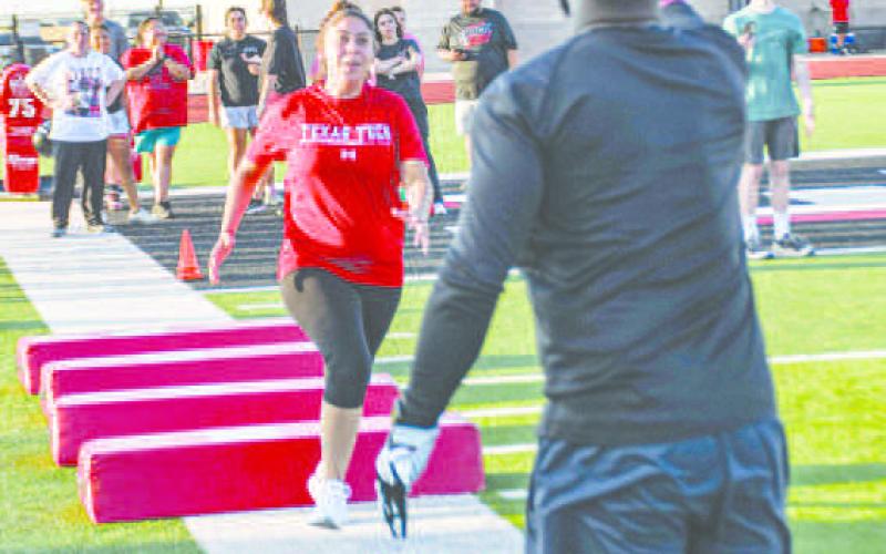 HIGH KNEES &amp;amp; CATCH – Joana Salas ran through the obstacles and made the catch during defensive drills at the Levelland Mom’s Football Clinic at Lobo Stadium on August 4. (Staff photo by Jentezen Smith)