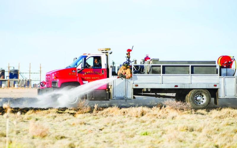 GRASS FIRE SEASON - Multiple Levelland Fire Department (LFD) units responded to a report of a small grass fire near America Road and Juneau Road, Monday evening. The responding units took turns encircling the burning area while also focusing on any hot spots. (Staff photo by Dom Puente)
