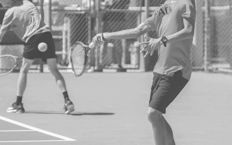 SMOOTH FOLLOW THROUGH - Junior Lobo Eben Castillano finished this fall season for the Lobo Tennis Pack with 29 wins and has a total of 65 varsity wins. Pictured is Castillano returning the ball during a doubles match at home. (Staff photo by Dom Puente)