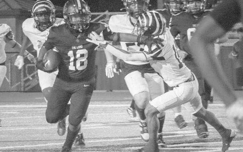 OUT MY WAY - Levelland Lobo Noah Martin moved the Snyder Tiger defender out of his way on his big run last Friday at home. (Staff photo by Aalijah Soliz)