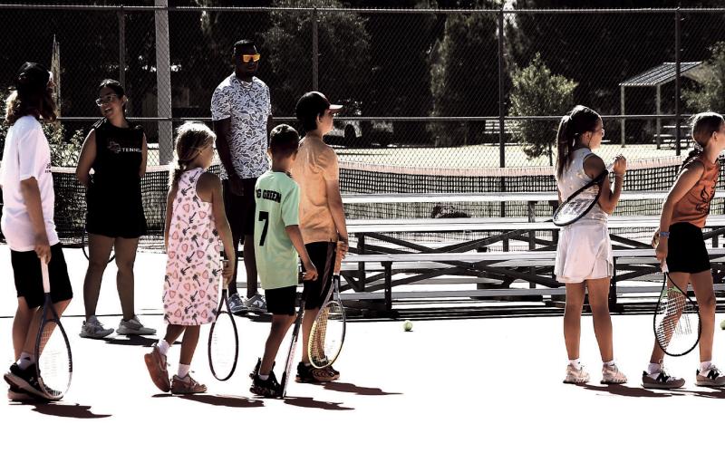 CAMPERS ON DECK- Young tennis players wait in line for their turn during a target-hitting drill at summer tennis camp. The multi-day camp gave local youth kids a chance to build athletic skills and stay active over the summer break.