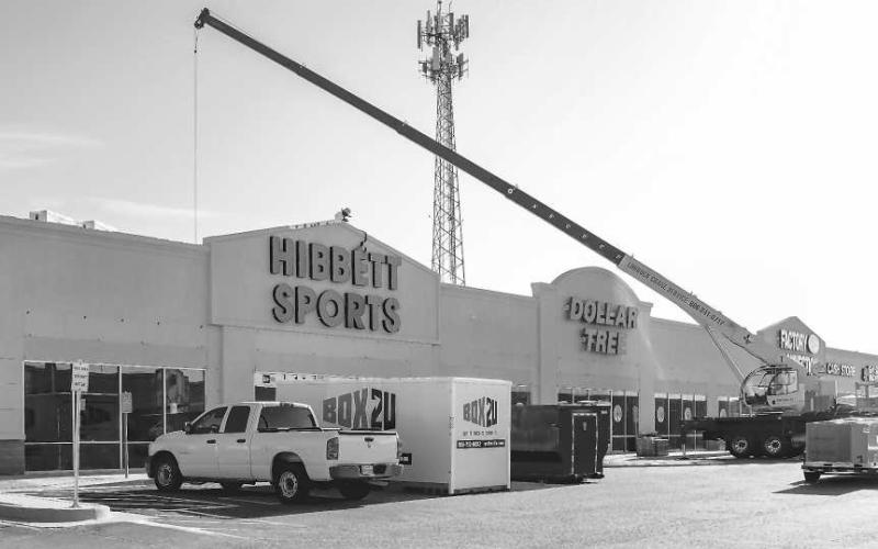 NEW ROOFING - Roofers have been working on the roof of the building that houses Hibbett Sports and Dollar Tree during this past week. (Photo courtesy of Emily Campos)