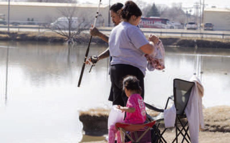 ENJOYING FISHING TIME— Pictured is a family takeing advantage of the warmer temperatures earlier this week by fising at Lobo Lake. Residents can enoy time outside at one of the many parks around town. (Staff photo by Eric Venkatesan)