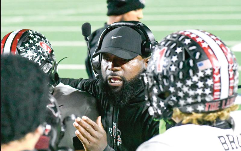 COACH ‘EM UP - Levelland Football Assistant Coach Pete Richardson coaches up several Lobo players amidst a timeout during their football game against Liberty this past Friday at Patriot Stadium. (Staff photo by Jentezen Smith)