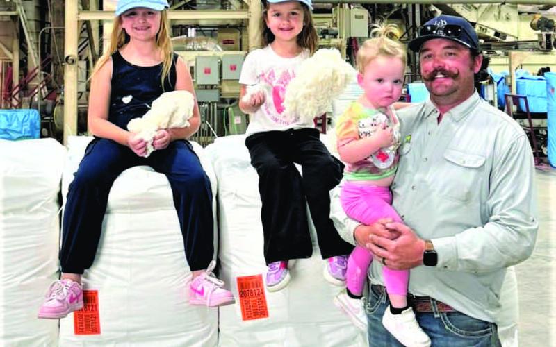 Producer Derik Pearson, shown with his three daughters, Lottie, Darcy and Corinne, brought in the cotton bale of the season at United Cotton Growers Cooperative in Hockley County.