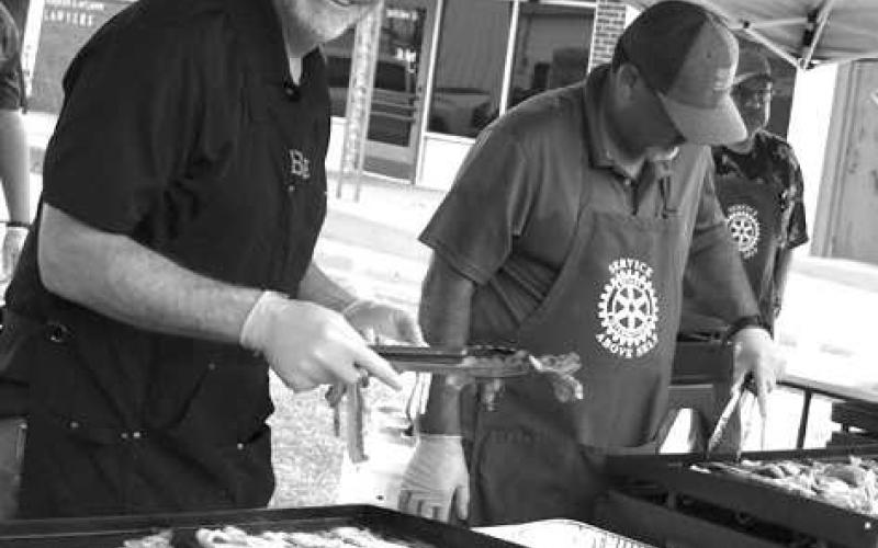 BACON BONANZA-- Bob Murray and Jorge Lopez with the Levelland Rotary Clubs, kept a watchful eye over their grittles during the Rotary’s Morning Breakfast that kicked-off the second annual Cotton &amp;amp; Crude Festival Saturday. (Submitted Photo by Delany Jackson)