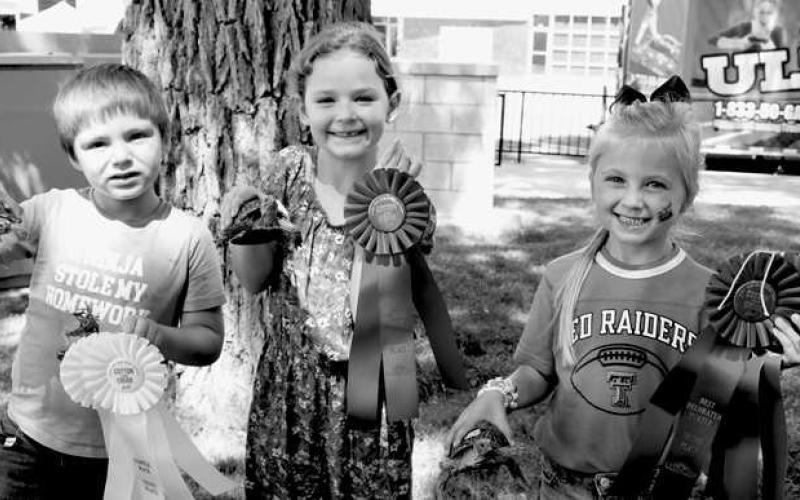 TURTLE RACE WINNERS-- The winners of the Cotton &amp; Crude annual Turtle Race proudly pose with their ribbons and turtles. Pictured from the left are: Benjamin Baigen and his tortoise “Otis” placed third; Kerrigan Boggs with her turtle “Lobo” placed second; and first place winner was Casey Daniel and her champion turtle “Rainbow Queen.” (Submitted Photo by Delany Jackson)