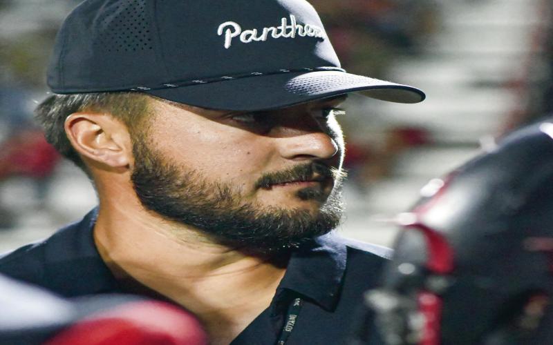 LOCKED IN - Whitharral Panthers Head Coach Josh Watson is locked in on the game as he instructs his team in the huddle. Watson would lead the Panthers to a 68-48 victory, making them 5-0 this season. (Staff photo by Jentezen Smith)