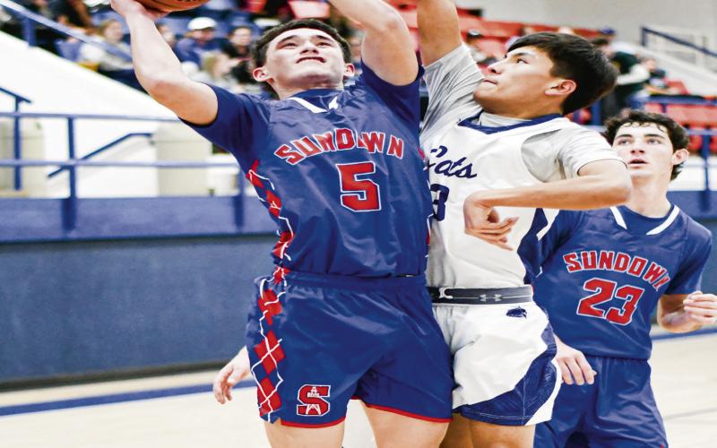 ROUGHNECKS VERSUS BOBCATS - Sundown Roughneck Coen Nevarez attempts a shot while Smyer Bobcat Sebastian Rodriguez contests his shot during their district basketball game at Smyer High School this past Friday night. (Staff photo by Jentezen Smith)