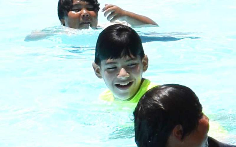 STAYING COOL – Pictured are local children playing at the Levelland City Pool. The pool is one of many way to cool off in 100 degree weather this summer. (Staff photo by Ada Niederhauser)