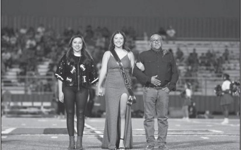 JUNIOR COURT - Junior Mackenzie Dominguez was escorted out on the field by her mother Amanda Moreno and grandfather Santos Moreno during homecoming last Friday. (Staff photo by Dom Puente)