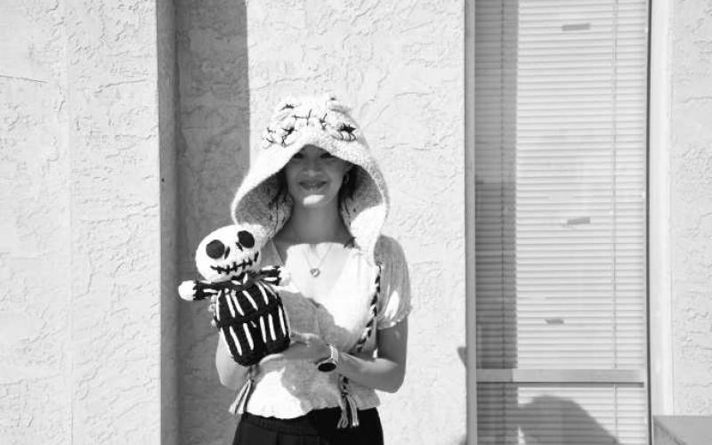 CRAFTING THE LOVE - Pictured is Rosabeth Garza with her own crocheted hooded scarf and a crocheted Nightmare Before Christmas Jack Skeleton. Garza can crochet you any character you want, just head to her Facebook, P and B Hook Creations and message her. (Staff photo by Hannah Woodrum)