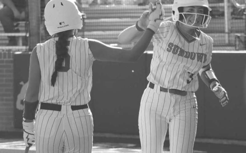 HIGH FIVE - Sundown Roughettes Destiny Garza and Ericka Posadas high-fived during the team’s game after Garza ran it in from third base to get the team a run. (Staff photo by Aalijah Soliz)