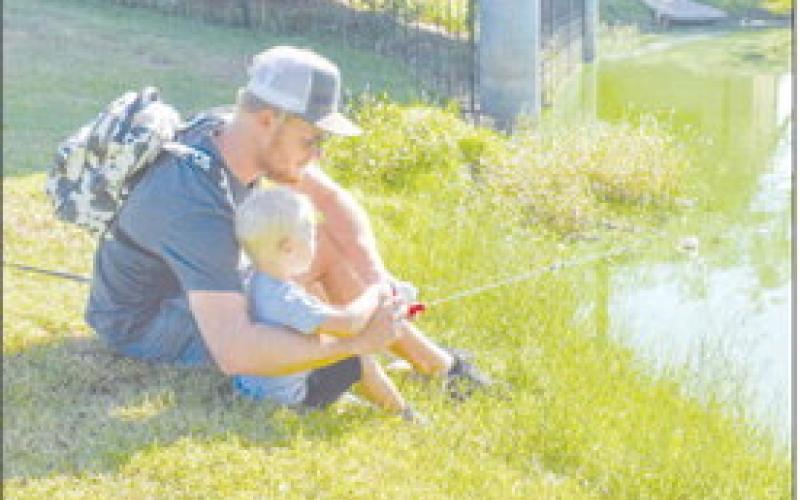 FISHING WITH DAD - Pictured are Jonny and Slater Friesen fishing with a little rod on Saturday at Lobo Lake at the Casting With Cops event. (Staff photo by Ada Niederhauser)