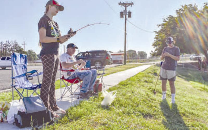 FAMILY FUN - Pictured are Elyssa, James and Brennon O’Bryon spending time fishing together at Lobo Lake at Casting With Cops on Saturday. (Staff photo by Ada Niederhauser)