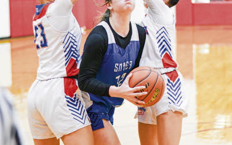 SPLIT THE DEFENDERS - Smyer Lady Cat Kaia Brandon splits two Sundown defenders during their district game this past Wednesday at Sundown High School. (Staff photo by Jentezen Smith) (See story on page 6 'Roughettes beat Lady Cats, 51-31')