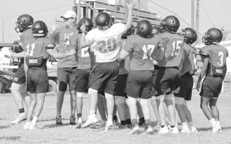 TEAM HUDDLE - Whitharral’s JV and Varsity teams huddled up to hear Assistant Coach Matt White’s instructions. (Staff photo by Aalijah Soliz)
