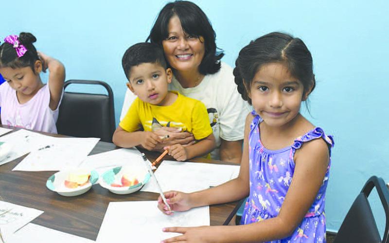 ART AND APPLES - Oak, Christian and Angie Rodriguez ate apples and drew photos during the weekly Summer Reading Program at the Hockley County Library Wednesday. The library will host Books and Bagels Wednesday July 12. (Staff photo by Victoria Byrnes)