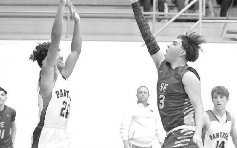 CONTESTING THE SHOT - Whitharral’s Nomar Gomez leaps up in the lane to contest a shot by Springlake-Earth senior, Micah Sanchez, during the first half of the Panther’s, 71-65, victory over the Wolverines in their Whitharral Tournament-Opener on Thursday. (Photo by Derek Lopez)