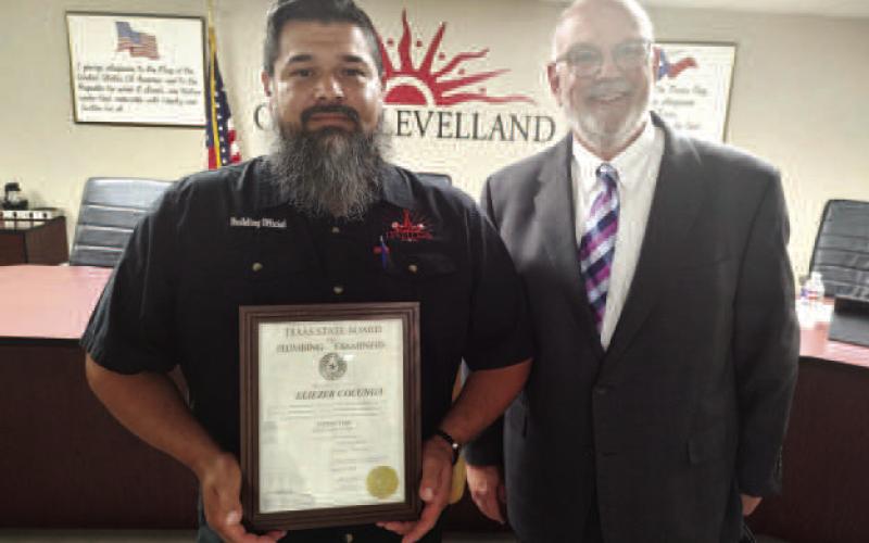 PLUMBING EXAMINER-- City manager James Fisher, in a presentation, recognized Eliezer Colunga for completing the Texas State Board of Plumbing Examiners requirements to become an inspector. (Staff photo)