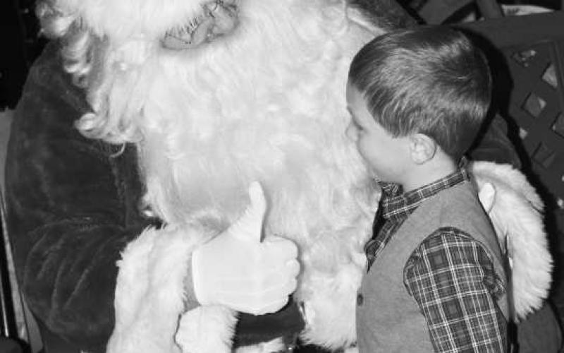 CHRISTMAS PALS - Wyatt Hopper got the thumbs-up sign from Santa after sharing his Christmas wishes under the Gazebo on the courthouse lawn in Levelland. Families and children from the community waited in line patiently to take photos and share Christmas wishes with Santa. (Photo Courtesy of Delany Jackson)