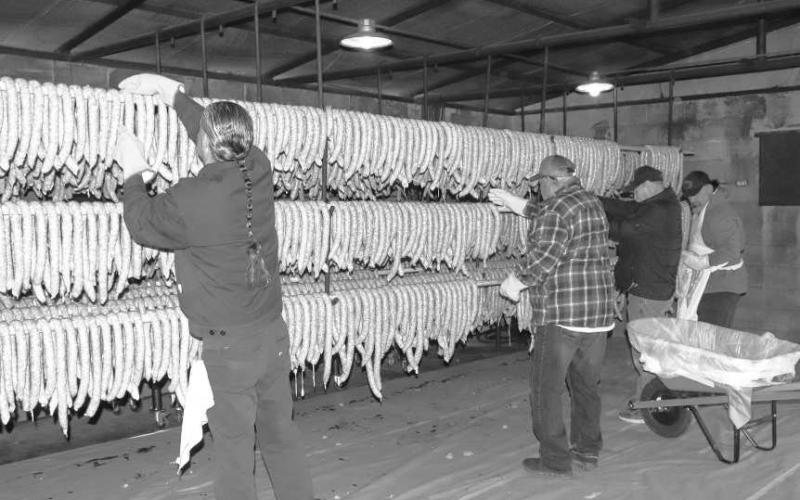 WORKINGINTHE SMOKEHOUSE - Pictured is Jerry Gonzalez, Vidal Hinojosa and Freddy Ruiz preparing the sausage in the smokehouse for the 40th Annaul Sausage Lovers Festival which will be held Sunday, Feb. 16 at St. Michael Catholic Church. (Staff photo by Adriana Solis)