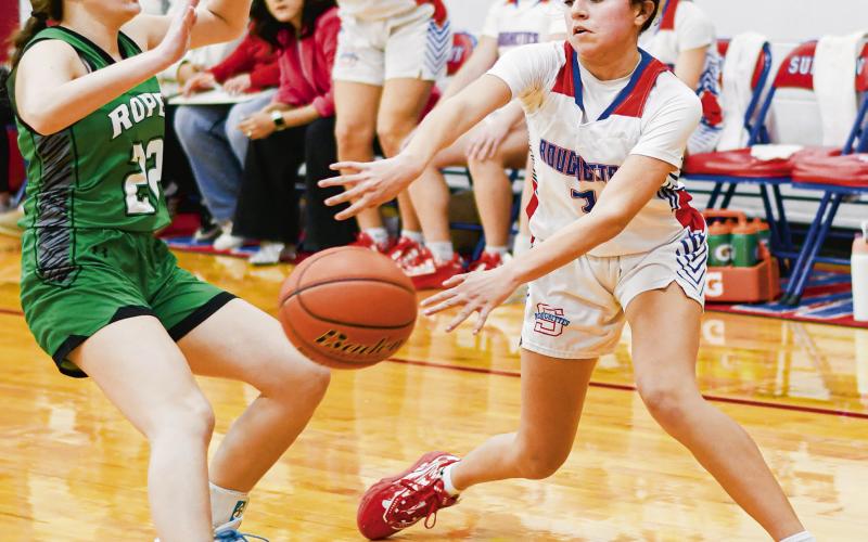 MCGLASSON BOUNCE PASS - Sundown Roughette Avyian McGlasson performs a bounce pass while Ropes Lady Eagle Karli Rhoads plays defense. (Staff photo by Jentezen Smith)