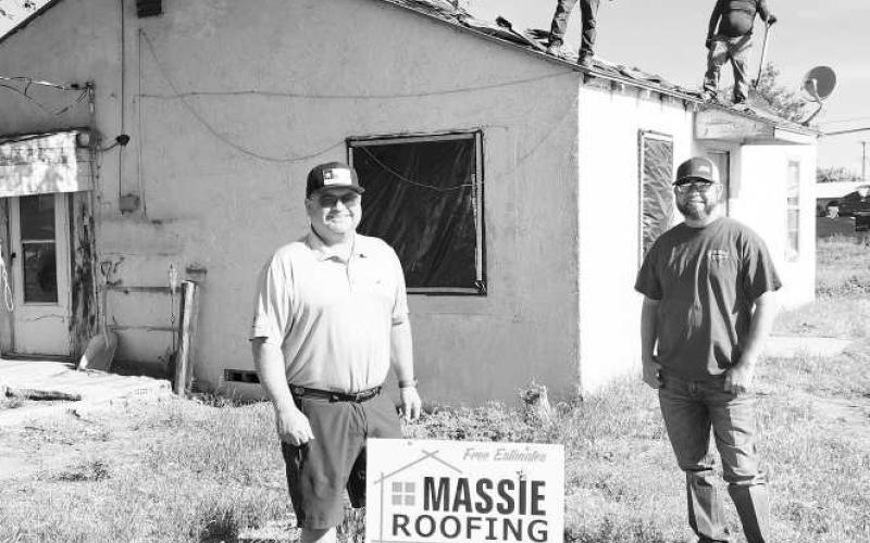 A HELPING HAND - Jeremiah Gavina and Jerald Massie of Massie Roofing volunteered their services to help a Levelland citizen receive a new roof. John Greenwood with ABC donated the shingles for the project. Pictured is Massie (left) and Gavina (right) with their crew working on removing the old shingles. South Plains Community Action has been gathering volunteers to help with the overhaul of the home. (Staff photo by Dom Puente)
