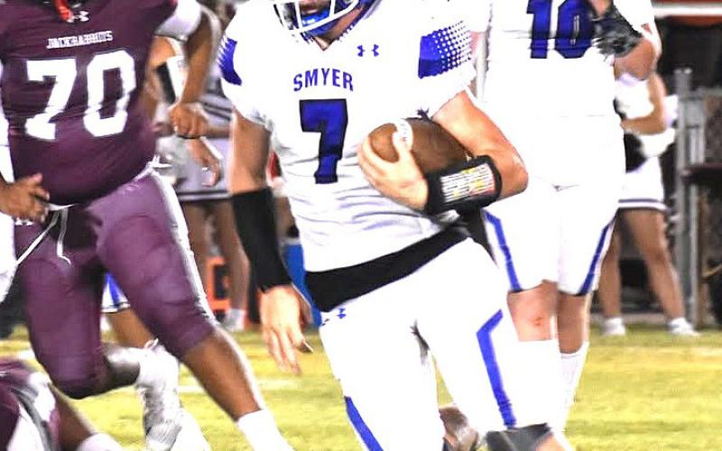(right photo) Smyer Bobcat Alex Mattox darts around the Ralls defense during the game last Friday.