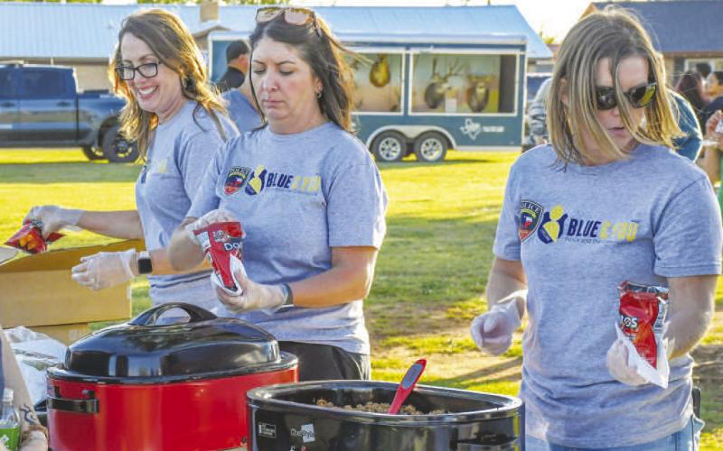 BLUE &amp;amp; YOU VOLUNTEERS - Pictured from left to right are: Andrea Corley, Megan Tyler and Amber Smith taking part in Texas Night Out as Blue &amp;amp; You volunteers. Walking Tacos were the food of choice for the event at Kauffman Park last Tuesday evening. (Staff photo by Evin Thomas)