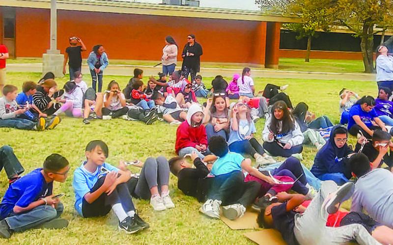 SOLAR ECLIPSE SIGHTING - Students across Levelland ISD took time out of their day to observe the rare solar eclipse that happened Monday afternoon. Pictured are students from Capital Elementary enjoying their time outside observing the eclipse with their special shades. (Photo courtesy of Emily Campos)