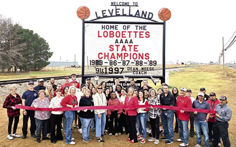 NEW LOCATION-- The ribbon cutting for the restored and relocated Loboettes State Champions sign on Friday. The event drew city administration, city council members, Levelland Chamber of Commerce and KLB, LISD coaches and administration, former and current Loboettes basketball players, staff from Butch’s and Allied Oilfield among many others. (Staff photo by Lynda Work)