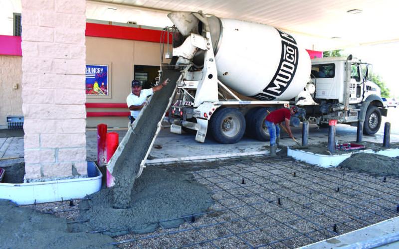 LAYINGCEMENT– An eight man crew with JNI Contractors of Lubbock, were laying 100 yards of cement at the United Supermarket Express recently. After the concrete is set, the new pumps will be installed and in approximately two weeks will be reopened for business. (Staff Photo by DeeLaine Ruiz)