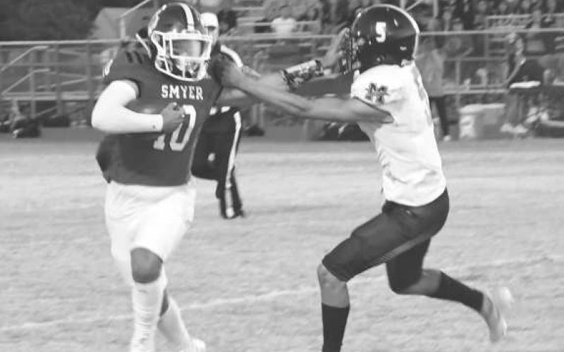 STIFF ARM - Smyer’s Peyton Casillas fended off Morton’s Alex Lopez in a 29-6 Smyer home loss last Friday. Smyer will be in Seagraves next while Morton will travel to New Home to face-off against an undefeated powerhouse. Both games will be on Friday at 7 p.m. (photo by Jay Kelley)