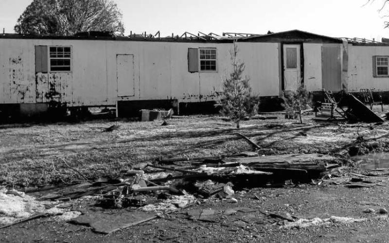 DESTRUCTION OF HOMES – Many residents are facing large repairs for their homes following the storm Wednesday. Roofs were destroyed along with windows blown out by large pieces of hail. Many homes also had their sidings littered with holes from the hail. Pictured is a mobile home that was ravaged by the winds and hail. (Staff photo by Karin Riddle)