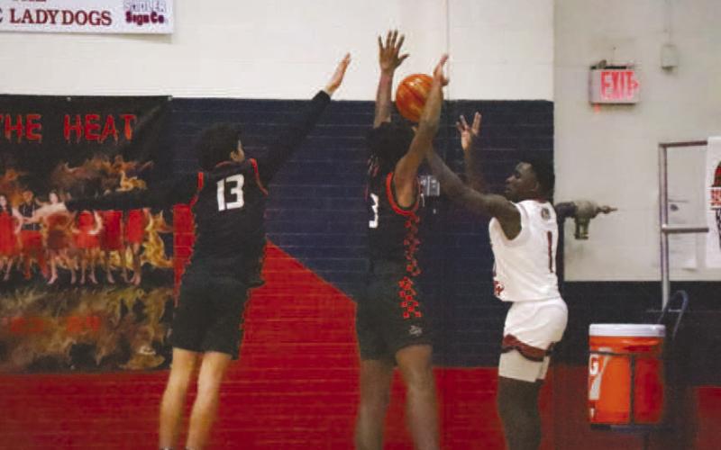 GET UP - Levelland athletes Ethan Salazar and Eryk Jones got up to block the three point attempt last Friday during the teams season opener. (Staff photo by Aalijah Soliz)