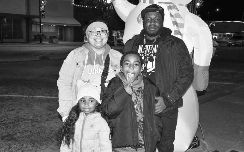 CHRISTMAS CHEER – From left, Laila, Isabella, Kameron and Kyrus posed with the courthouse Christmas decorations in downtown Levelland during the Christmas on the Square event Dec. 5. (Staff photo by Evin Thomas)