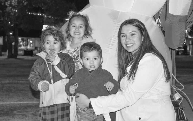 SWEET EVENT – From left, Cynthia, Sophia, Xavier and Britney posed with their candy canes after meeting Santa at the courthouse lawn gazebo during Levelland’s Christmas on the Square on Dec. 5. (Staff photo by Evin Thomas)