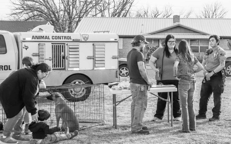 ADOPTION BOOTH - The Levelland Animal Shelter hosted an adoption booth during the first “Cops and Communities” held by the Levelland Police Department Thursday at Kauffman Park. Pictured are community members talking with Animal Shelter staff and playing with the animals that could be adopted. (Staff photo by Essence Childers)