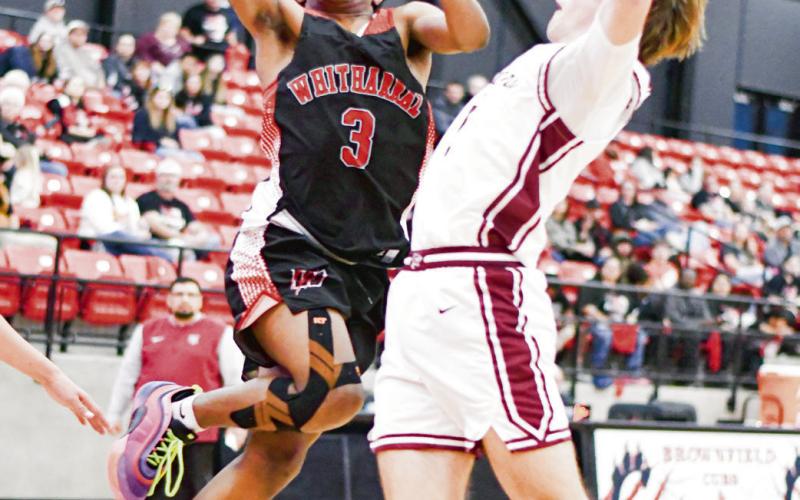 ACROBATIC FINISH - Whitharral Panther Brent Robinson goes up for the acrobatic finish while a Klondike de fender contests it during their playoff basketball game this past Monday night at Brownfield High School. (Staff photo by Jentezen Smith)