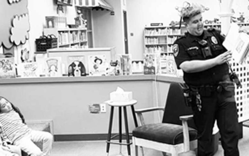 COMMUNITY READING - Librarian Abi Swain invited community members to come read to the students at Levelland Academic Beginnings Center. It was a learning experience on both sides as the students like to meet new people and the adults, get to see just how smart the students at LABC are. Pictured is Officer Josh Rincones reading 'Where the Wild Things Are' by Maurice Sendak, 1963. (submitted photo by Cristal Isaacks)
