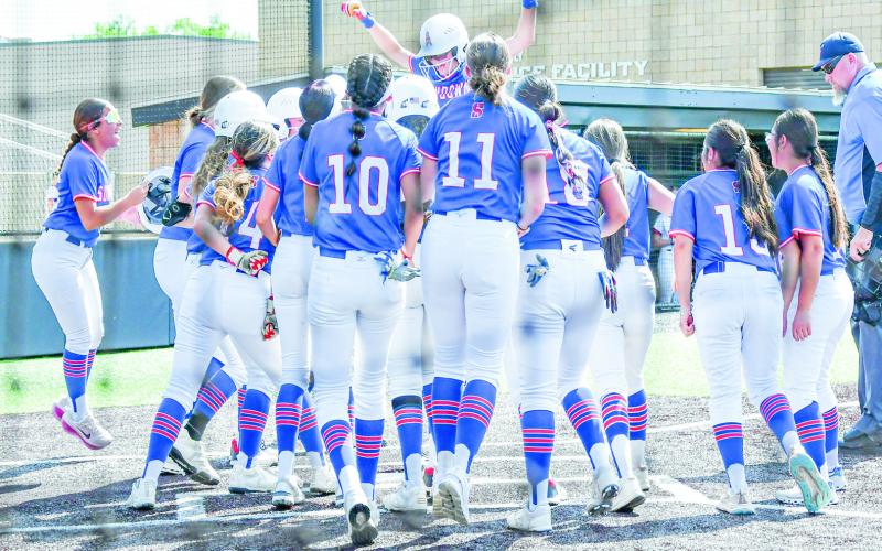 HOME RUN CELEBRATION - The Sundown Roughettes celebrate as a team at home plate after Breigh Gregory hits a home run during game two of their playoff softball series against Muenster this past Saturday at Abilene Christian University. (Staff photo by Jentezen Smith)